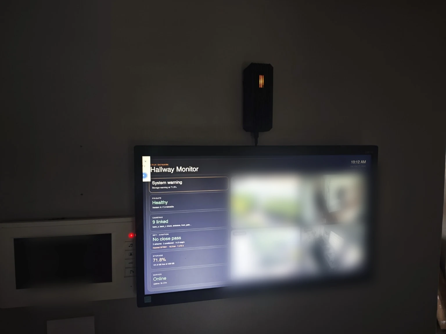 Installed Atlas Bridge above the CRUX Daymark hallway monitor. The monitor content is softly obscured in this publication preview to avoid exposing household camera imagery.