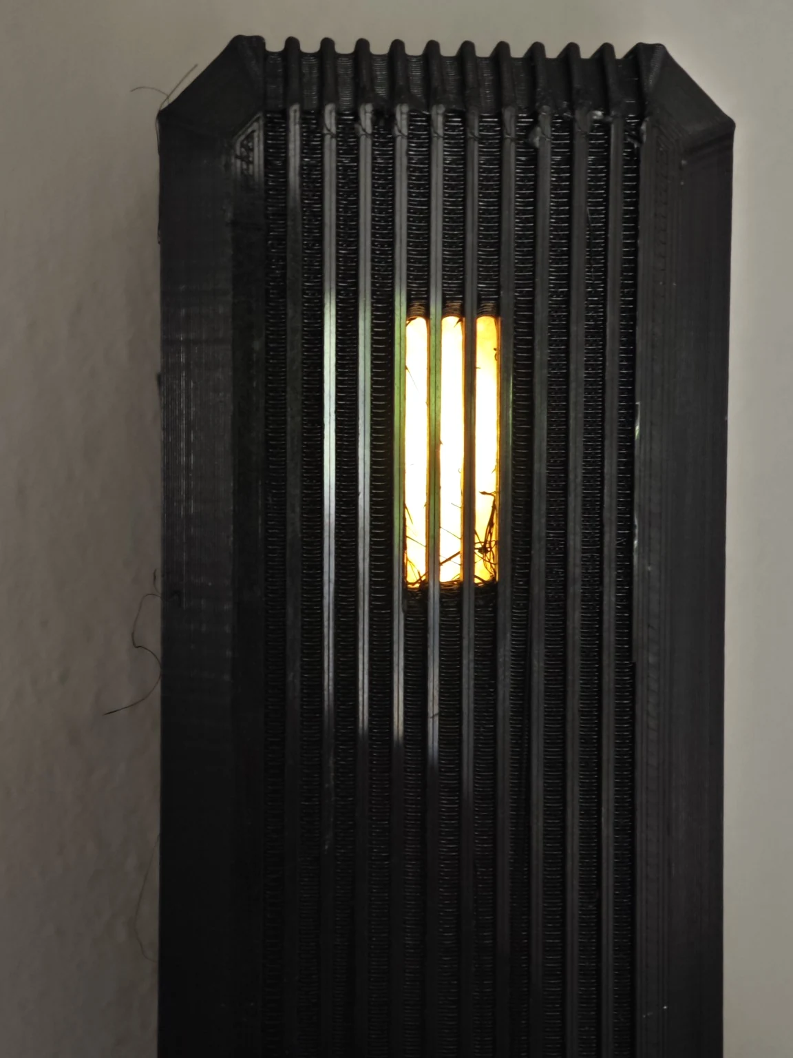 Front-facing documentary close-up of the Atlas Bridge light aperture showing three illuminated segments between black ribs